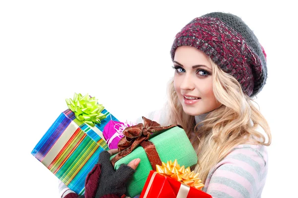 Μια φωτογραφία του την όμορφη κοπέλα είναι σε χειμωνιάτικα ρούχα με χρωματιστοί δώρο κουτιά, απομονωμένη — Φωτογραφία Αρχείου