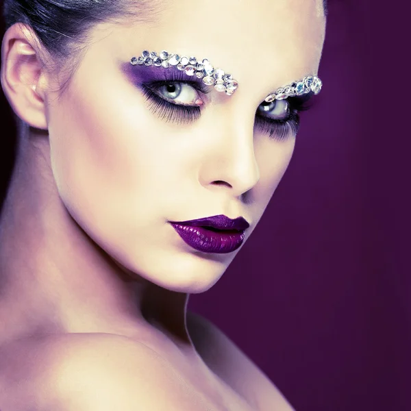 Ritratto di bella ragazza sessuale con strass sul viso, su sfondo viola — Foto Stock