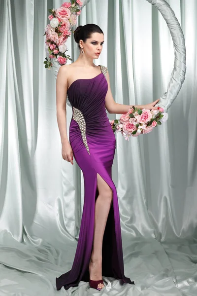 Όμορφη μελαχρινή σεξουαλική σε n Βραδυνό φόρεμα με το τσέρκι με ροζ λουλούδια — Φωτογραφία Αρχείου