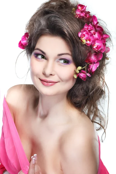 Porträt der schönen sexuellen Brünette mit rosa Orchideen im Haar. Emotionen, Kosmetik — Stockfoto