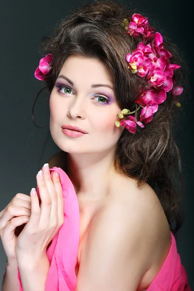 Retrato de bela morena sexual com orquídeas rosa nos cabelos. emoções, cosméticos — Fotografia de Stock