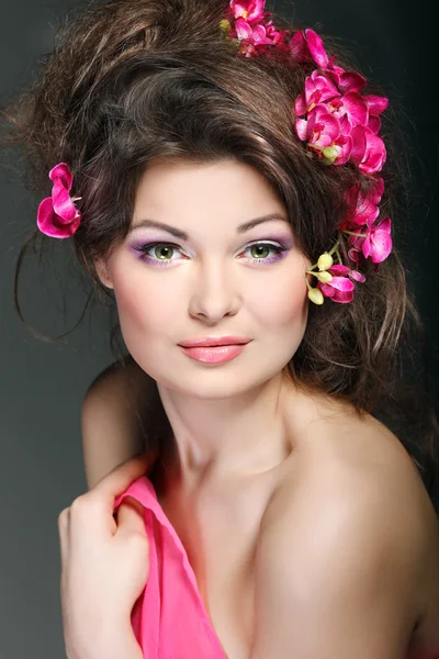 Retrato de hermosa morena sexual con orquídeas rosadas en pelos. emociones, cosméticos — Foto de Stock
