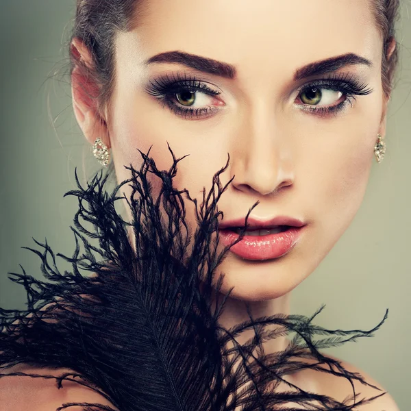 Closeup portrait of sexy whiteheaded young woman with black feather  on grey  background — Stock Photo, Image