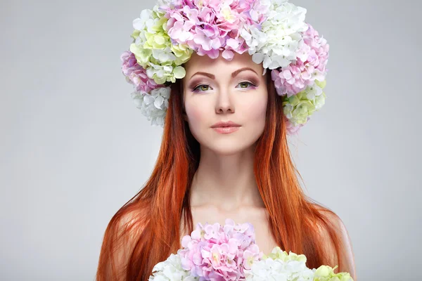 Retrato de cerca de una hermosa joven pelirroja en una chaplet con flores — Foto de Stock