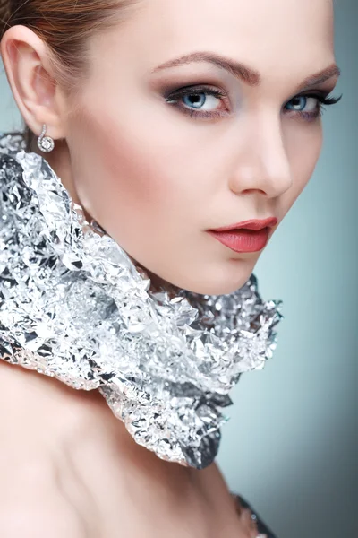 Bella ragazza con lamina di metallo argentata su un collo, isolata su uno sfondo grigio chiaro, emozioni, cosmetici — Foto Stock