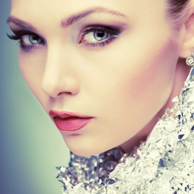 ışık - izole gri arka plan, duygular, kozmetik bir boyun, metalik gümüş folyo ile güzel kız