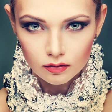 ışık - izole gri arka plan, duygular, kozmetik bir boyun, metalik gümüş folyo ile güzel kız