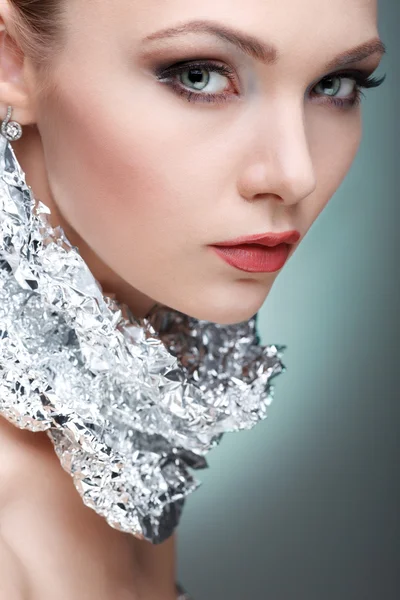Menina bonita com folha metálica de prata em um pescoço, isolado em uma luz - fundo cinza, emoções, cosméticos — Fotografia de Stock