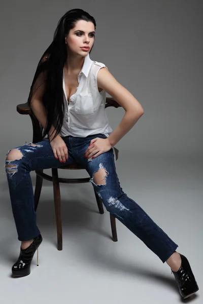 Photo of beautiful sexual brunette, sitting on a brown wooden chair, fashion style, glamour — Stock Photo, Image