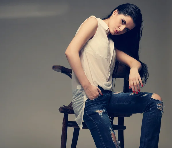 Photo of beautiful sexual brunette, sitting on a brown wooden chair, fashion style, glamour — Stock Photo, Image