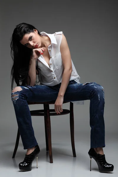 Photo of beautiful sexual brunette, sitting on a brown wooden chair, fashion style, glamour — Stock Photo, Image