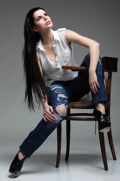 Photo of beautiful sexual brunette, sitting on a brown wooden chair, fashion style, glamour — Stock Photo, Image