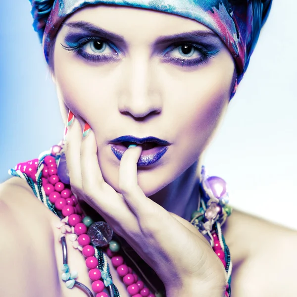 A photo of beautiful  girl in a head-dress from the coloured fabric,on a blue background,  glamour — Stock Photo, Image