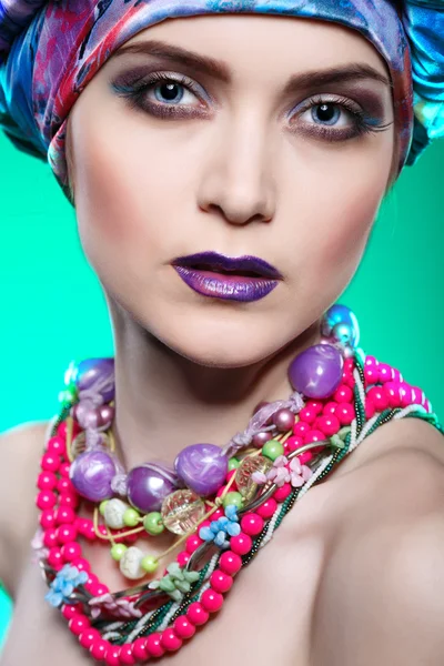 Egy gyönyörű lány, egy fej-ruha a színes szövet, kék háttérrel, glamour fotó — Stock Fotó