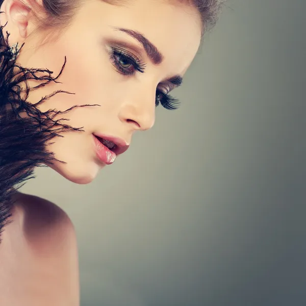 Portret seksowny whiteheaded młoda kobieta z czarne pióro na szary tło zbliżenie — Zdjęcie stockowe