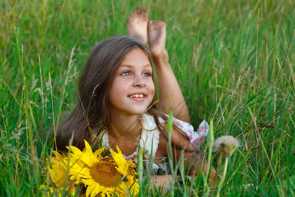 Kleines fröhliches Mädchen mit gelb auf grün auf einer Wiese, Emotionen, Lebensstil — Stockfoto