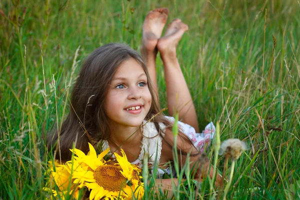 Liten glad flicka med gul på gröna en äng, känslor, livsstil — Stockfoto