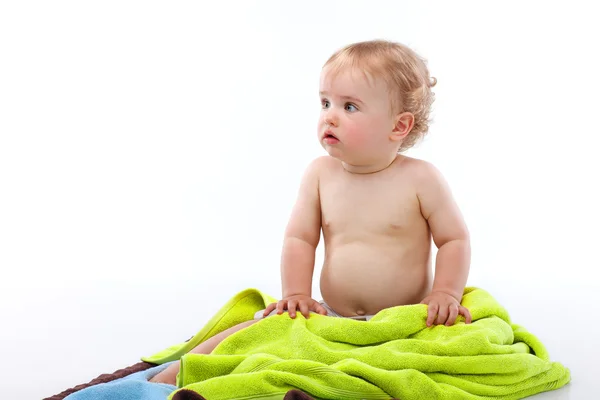 Blond baby boy on colorful towels — Stock Photo, Image