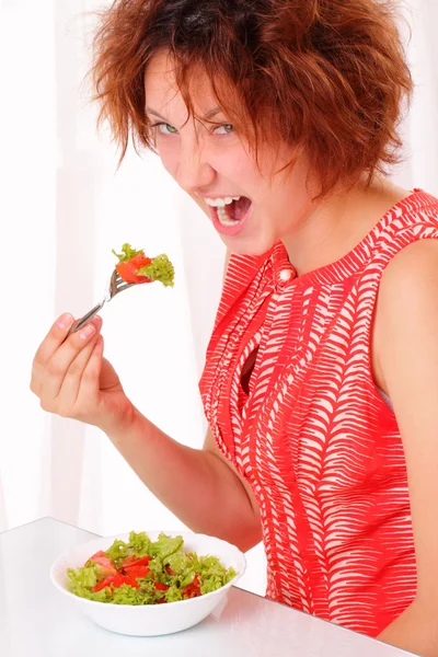 Rapariga irritada comendo salada saborosa — Fotografia de Stock