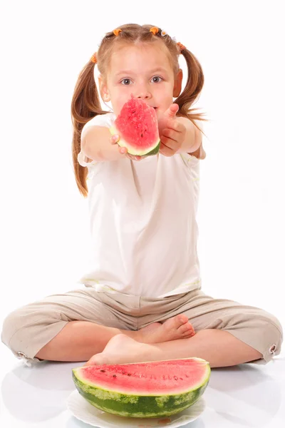 Attractive little girl gives a piece of watermelon — Stock Photo, Image