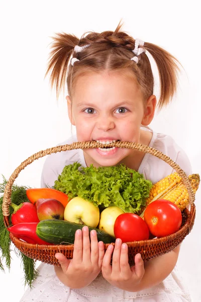Смешная маленькая девочка с овощами и фруктами — стоковое фото