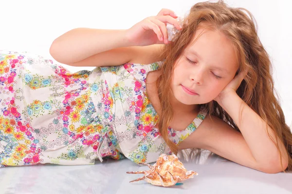 Calm little girl with seashell and starfish — Stock Photo, Image