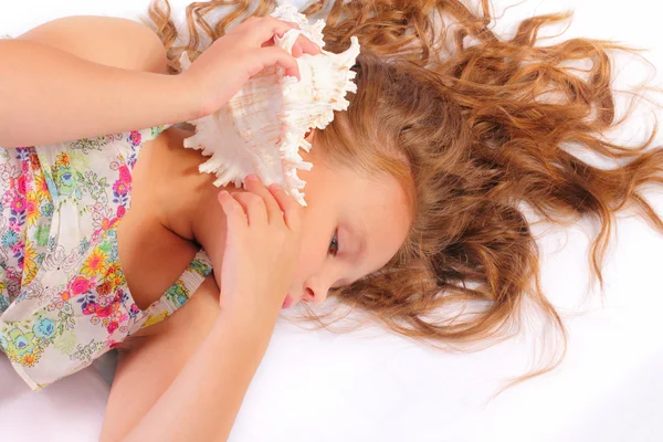 Quiet little girl with seashell — Stock Photo, Image