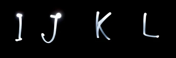 I, J, K, L - Pictured by light letters. on black — Stock Photo, Image