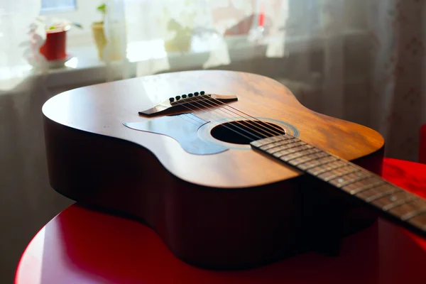 Masanın üzerinde yatan akustik gitar — Stok fotoğraf