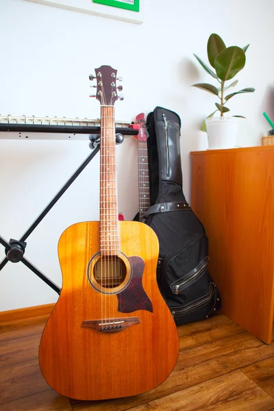Muziekinstrumenten zijn in de buurt van witte muur van het appartement — Stockfoto
