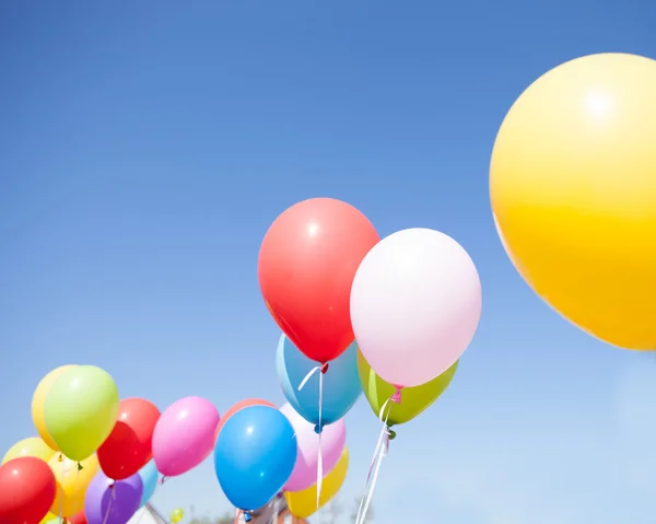 Flying colorful balloons against blue sky — Stock Photo, Image