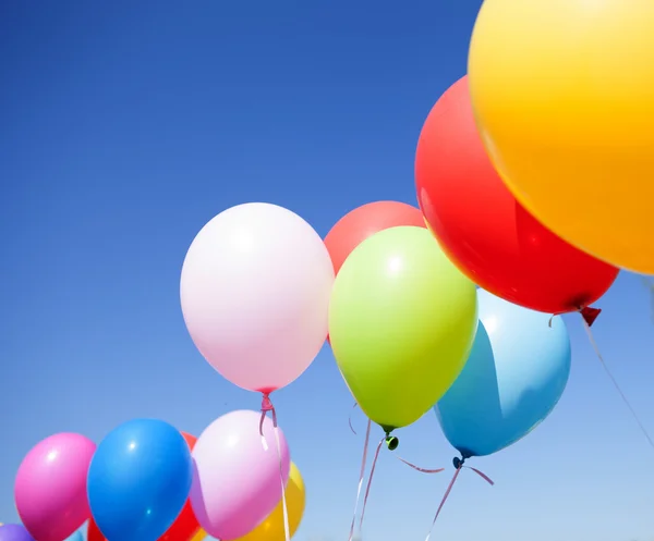 Mavi gökyüzüne uçan renkli balonlar — Stok fotoğraf