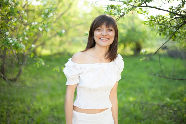 Portrét mladé brunetky na jarní zahradě — Stock fotografie