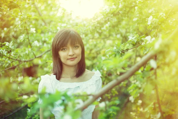 Mooie vrouw in een lente tuin — Stockfoto