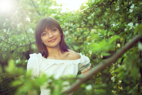 Portrét mladé brunetky na jarní zahradě — Stock fotografie