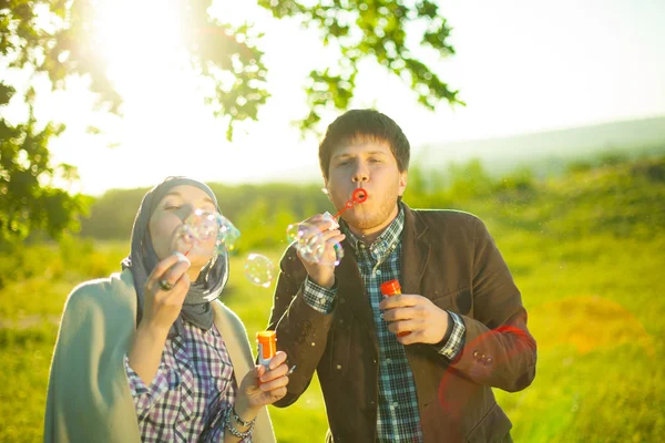 An engaged couple blows bubbles. — Stock Photo, Image