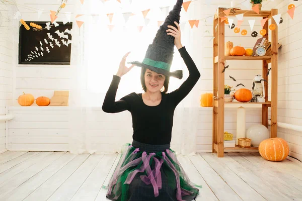ハロウィンのお祝いのための準備ができて魔女衣装の若い美しい女性ハロウィンルーム装飾 — ストック写真