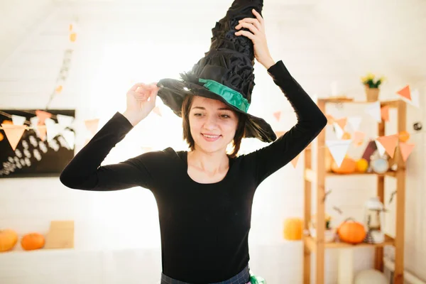 Молодая красивая женщина в костюме ведьмы готова к празднованию Хэллоуина в украшении комнаты Хэллоуина — стоковое фото