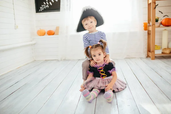海賊の衣装を着た少年と魔女の衣装を着た少女は自宅でハロウィンを祝います — ストック写真