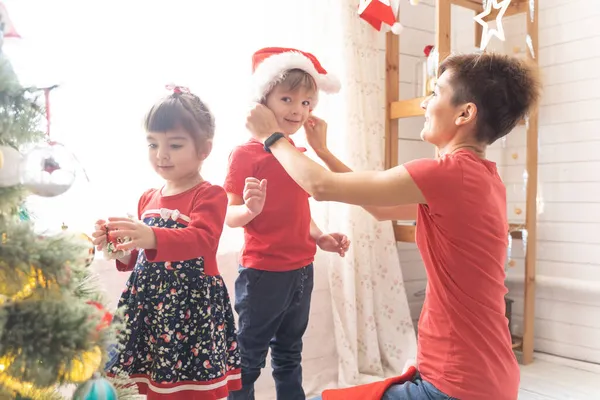 Familia abriendo regalos de Navidad en casa juntos Fotos De Stock Sin Royalties Gratis