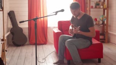 Adam gitar çalıyor ve şarkı söylüyor