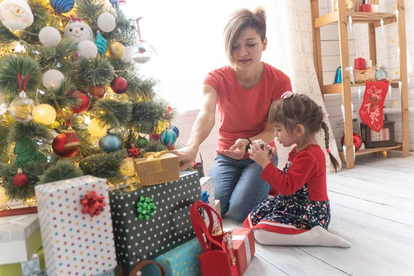 Familia abriendo regalos de Navidad en casa juntos Fotos De Stock