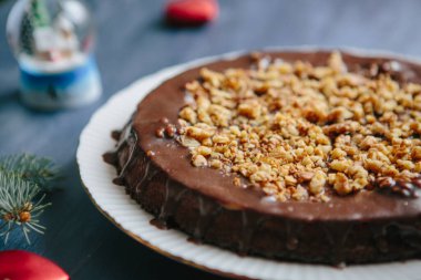 Noel masasında kır evleri ve zencefilli kurabiyeler Glüten ücretsiz Noel fındıklı kek gri bir masada Noel süslemeleri ile