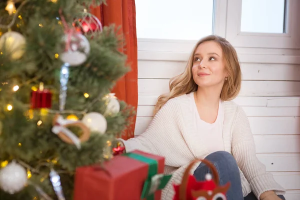 Hermosa mujer joven decorando un árbol de Navidad en casa Imágenes De Stock Sin Royalties Gratis