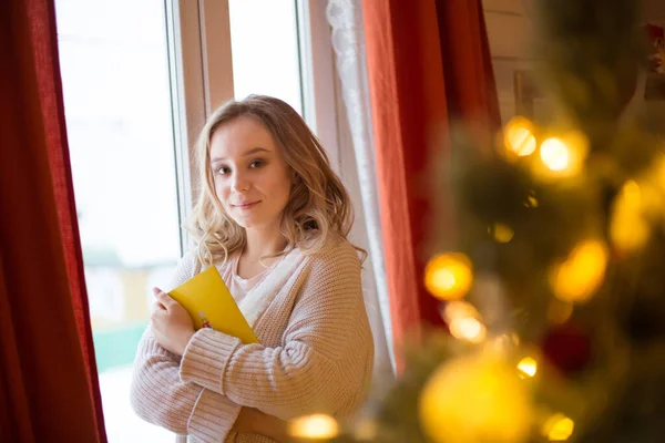 Bella, giovane donna che decora un albero di Natale a casa Immagini Stock Royalty Free