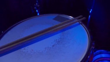 Drumsticks on a snare drum in a nightclub