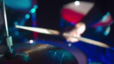 Davulcu sopalarla yüksek şapkaya vurur.