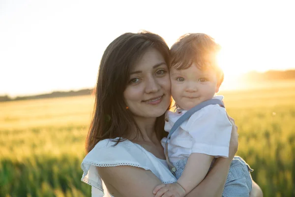 夏天的母亲和儿子在日落时的性质的肖像 免版税图库图片
