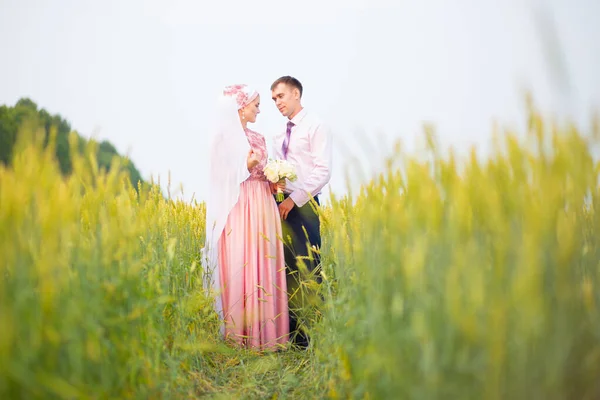 Brud och brudgum i fält. Muslimskt äktenskap. Stockbild