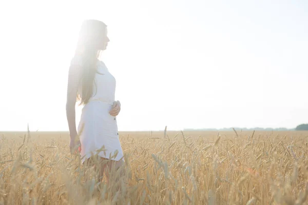 Jolie jeune femme dans le champ au coucher du soleil . — Photo